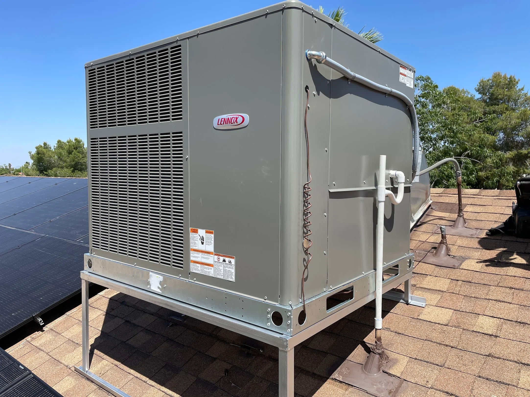 Lennox AC unit on roof with louvered panels, copper lines, and metal mounting frame