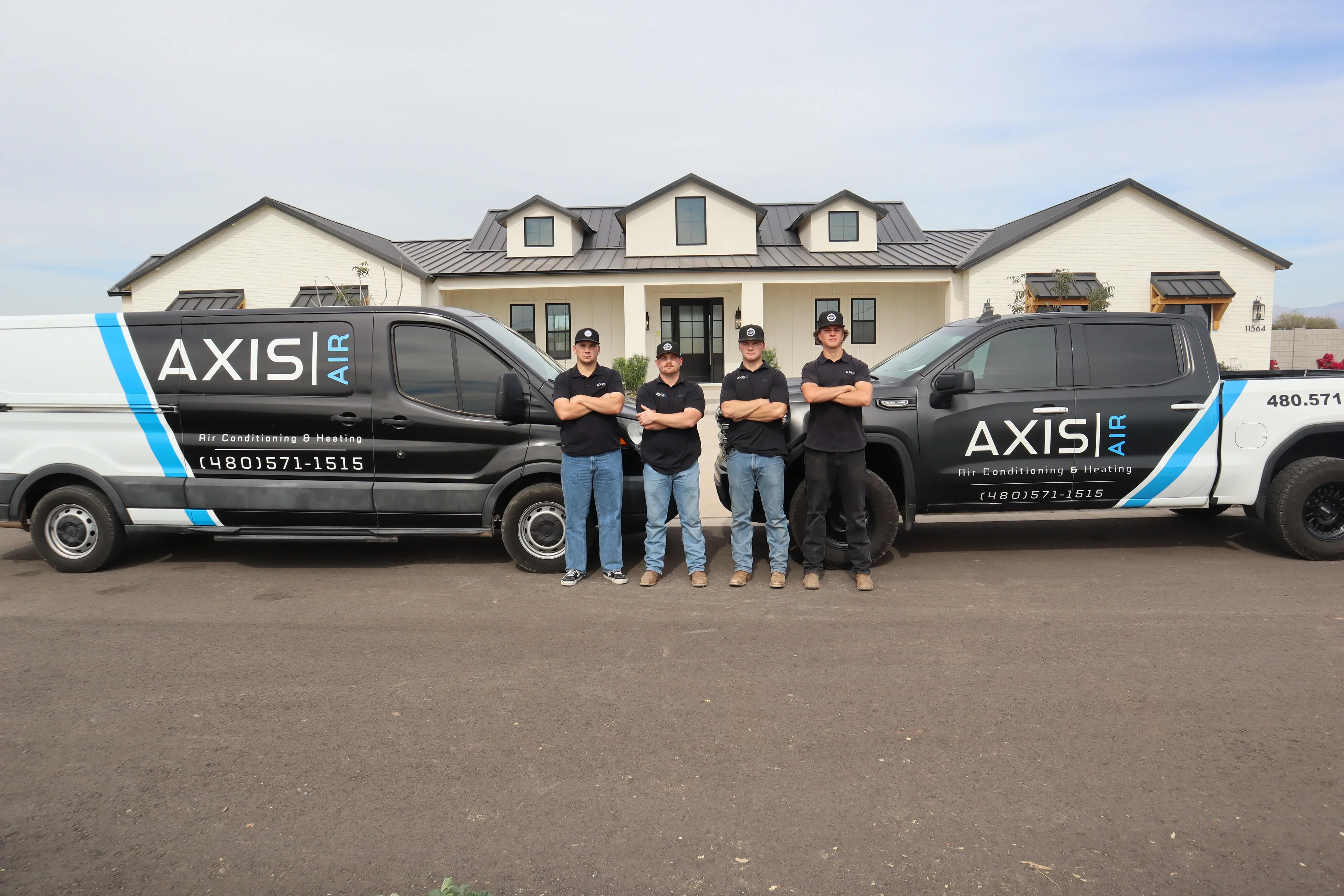 HVAC service team with two branded service vans in front of residential home