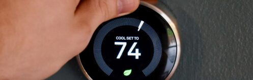 Hand adjusting temperature on a thermostat