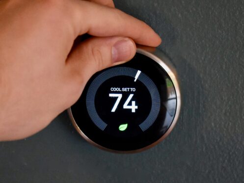 Hand adjusting temperature on a thermostat